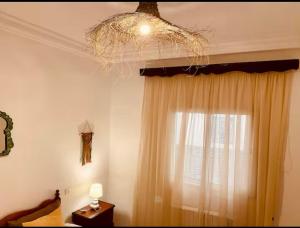 a room with a window with a chandelier and a curtain at Studio Authentique à Sidibousaid in Dar Salah Bey