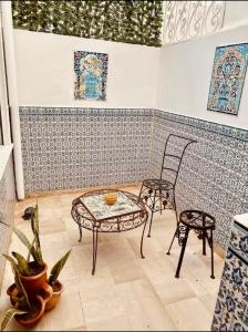 a room with a table and two chairs and a wall at Studio Authentique à Sidibousaid in Dar Salah Bey