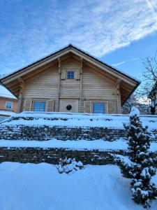 a log cabin with snow in front of it at Ferienhaus Blick Hasserode in Wernigerode