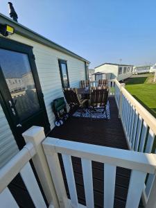 a deck with chairs and a table on a house at V10 static caravan in Ingoldmells