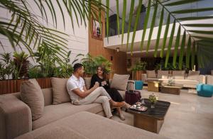 a man and woman sitting on a couch in a lobby at NearYo Hotels in Marrakesh +112 photos