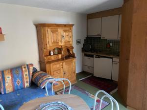 a living room with a couch and a kitchen at Cottage Grundschera Engadin in Brail