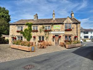 an old stone building with tables and chairs at The Lower Buck Inn in Clitheroe