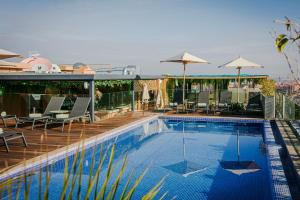 a swimming pool with chairs and umbrellas on a building at NearYo Hotels in Marrakesh