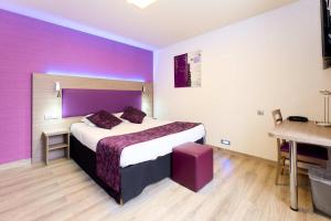 ein Hotelzimmer mit einem großen Bett und einem Schreibtisch in der Unterkunft The Originals City, Archotel, Sens in Sens