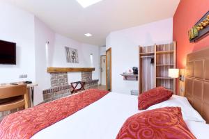ein Schlafzimmer mit einem großen Bett und einem Kamin in der Unterkunft The Originals City, Archotel, Sens in Sens