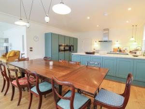 a large kitchen with a wooden table and chairs at Schiehallion House in Pitlochry