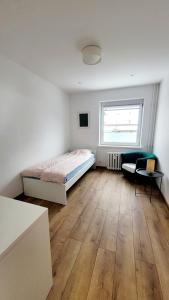 a bedroom with a bed and a chair and a window at Pokoje Gościnne Gdańsk Hallera in Gdańsk +14 photos