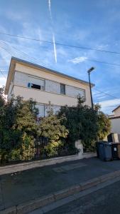 a house with a fence and trees in front of it at La Parenthèse Urbaine - T2 Cosy et fonctionnel - Metro 5 Bobigny in Bobigny