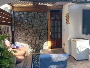 a living room with a stone wall and a door at villa des Filaos et du lagon 0693-70'59'79 in Saint-Leu