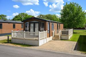 a small cabin with a porch and a deck at Jackson Lodge - Primrose in Malton