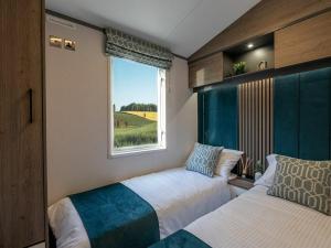 a small bedroom with two beds and a window at Jackson Lodge - Primrose in Malton