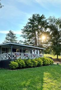 a building with the sun shining on it in the grass at The Cottage at Cardinal Hill in Dahlonega