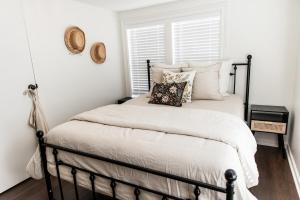 a bedroom with a black and white bed with pillows at The Cottage at Cardinal Hill in Dahlonega
