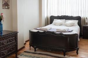 a black bed with towels on it in a bedroom at Moty's Guesthouse in Cusco