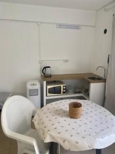 a small kitchen with a table and a microwave at Quarto, Algarve in Olhão