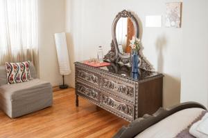 a dresser with a mirror and a chair in a room at Moty's Guesthouse in Cusco