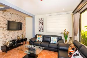 a living room with a leather couch and a brick wall at Coco Sunset Hills 52 in Coco