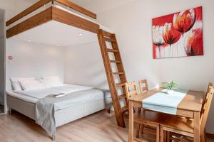 a bedroom with a bed and a desk with a ladder at Citykoti Downtown Studios in Helsinki