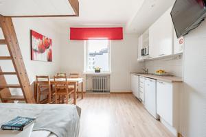 a kitchen and dining room with a table and chairs at Citykoti Downtown Studios in Helsinki