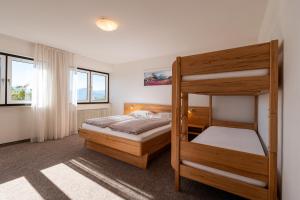 a bedroom with two bunk beds and a window at Pension Rastnerhof in Luson