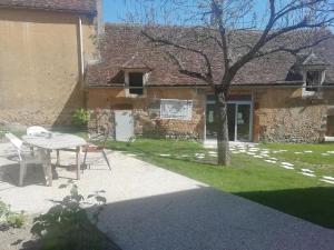 a table and chairs in front of a building at Auberge de Treigny - Les chambres in Treigny