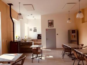 a room with tables and chairs and a kitchen at Auberge de Treigny - Les chambres in Treigny