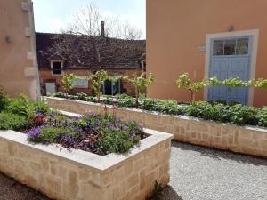a garden in front of a building with flowers at Auberge de Treigny - Les chambres in Treigny