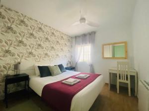 a bedroom with a white bed with a red blanket at Casa Verde - Ground floor apartment next to the beach in Torrox Costa +25 photos