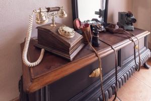 an old fashioned telephone on a dresser with a mirror at Sassari Station Inn in Sassari