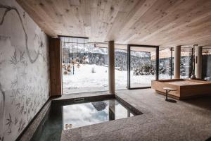 a room with a view of a snow covered mountain at Borgo Antico Mountain Lodge in Sappada