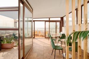 a patio with green chairs and tables in a building at Hotel Centrale in Syracuse
