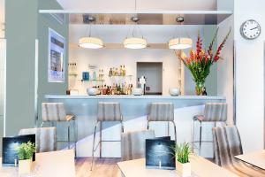 a room with tables and chairs and a counter at Garner Hotel Bremen City by IHG in Bremen