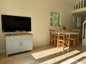 a living room with a table and a flat screen tv at Cozy guesthouse in Vallda in Vallda