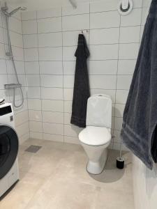 a bathroom with a white toilet and a black towel at Cozy guesthouse in Vallda in Vallda
