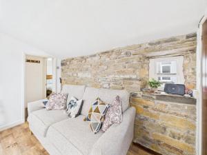 a living room with a couch and a stone wall at 52a Albert Street in Kirkwall