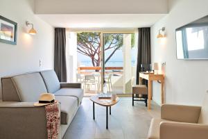 a living room with a couch and a table at Hôtel La Roya in Saint-Florent