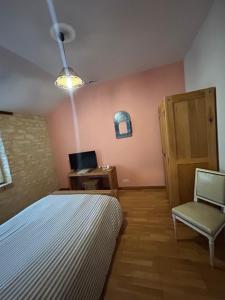 a bedroom with a bed and a chair and a desk at La Ferme de Francois in Saudron