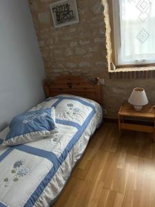a bedroom with a bed and a window and a table at La Ferme de Francois in Saudron +17 photos