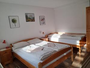 two beds in a room with white walls at Enikő vendegház in Praid