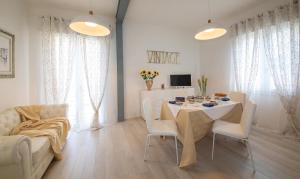 a white living room with a table and a couch at Lizard Residence in Lido di Jesolo