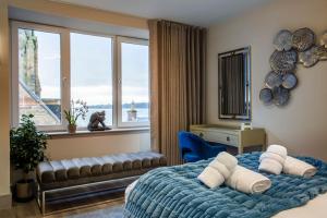 a bedroom with a bed with a blue blanket and windows at Arran Shores Luxury Shorefront Penthouse Suite 10 in Lamlash