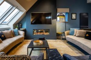 a living room with two couches and a fireplace at Arran Shores Luxury Shorefront Penthouse Suite 10 in Lamlash