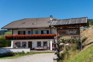 a house with flowers on the side of a hill at Pension Rastnerhof in Luson