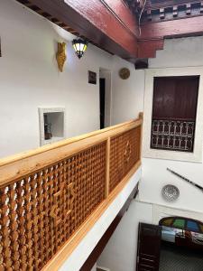 a stairway with a wooden railing and a window at DarMouniaFès in Fez