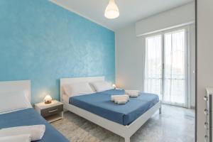 a blue bedroom with two beds with blue walls at Residence Mizar 2 in Pietra Ligure +66 photos