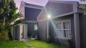 a blue house with a window and a yard at Frankie's Nest in Cape Town