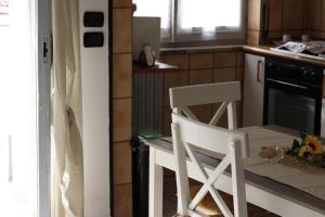 a kitchen with two white chairs and an oven at Situation House in Catanzaro Lido