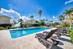 a pool with chaise lounge chairs next to a resort at Incredible Beach Front Villa! in George Town