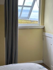 a bedroom with a window with a view of the ocean at Sanda View, Isle of Arran in Sliddery +49 photos